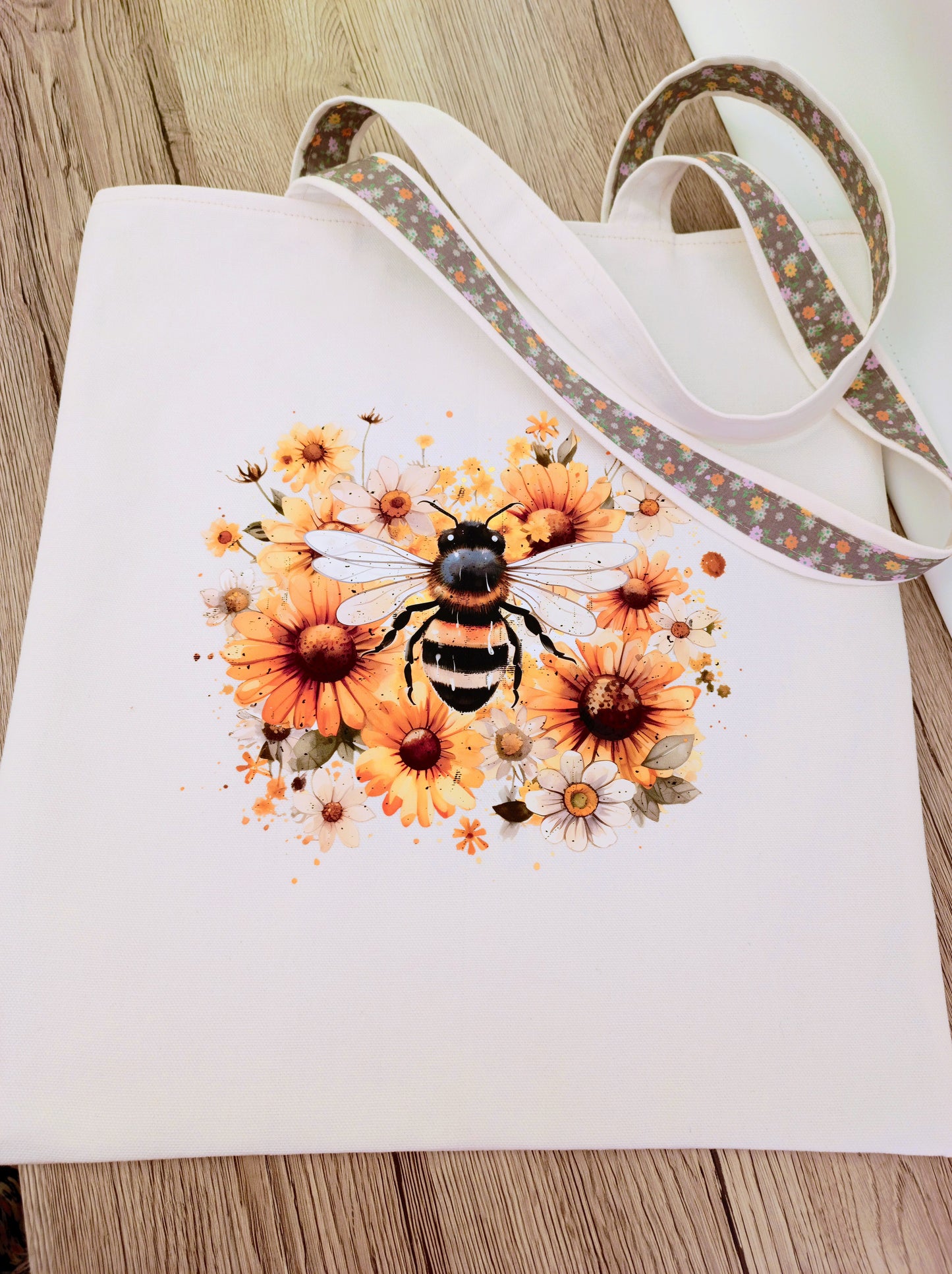 Handmade canvas tote bag with bee and flowers transfers, floral lining, sturdy shoulder straps, perfect for everyday use or gifts.